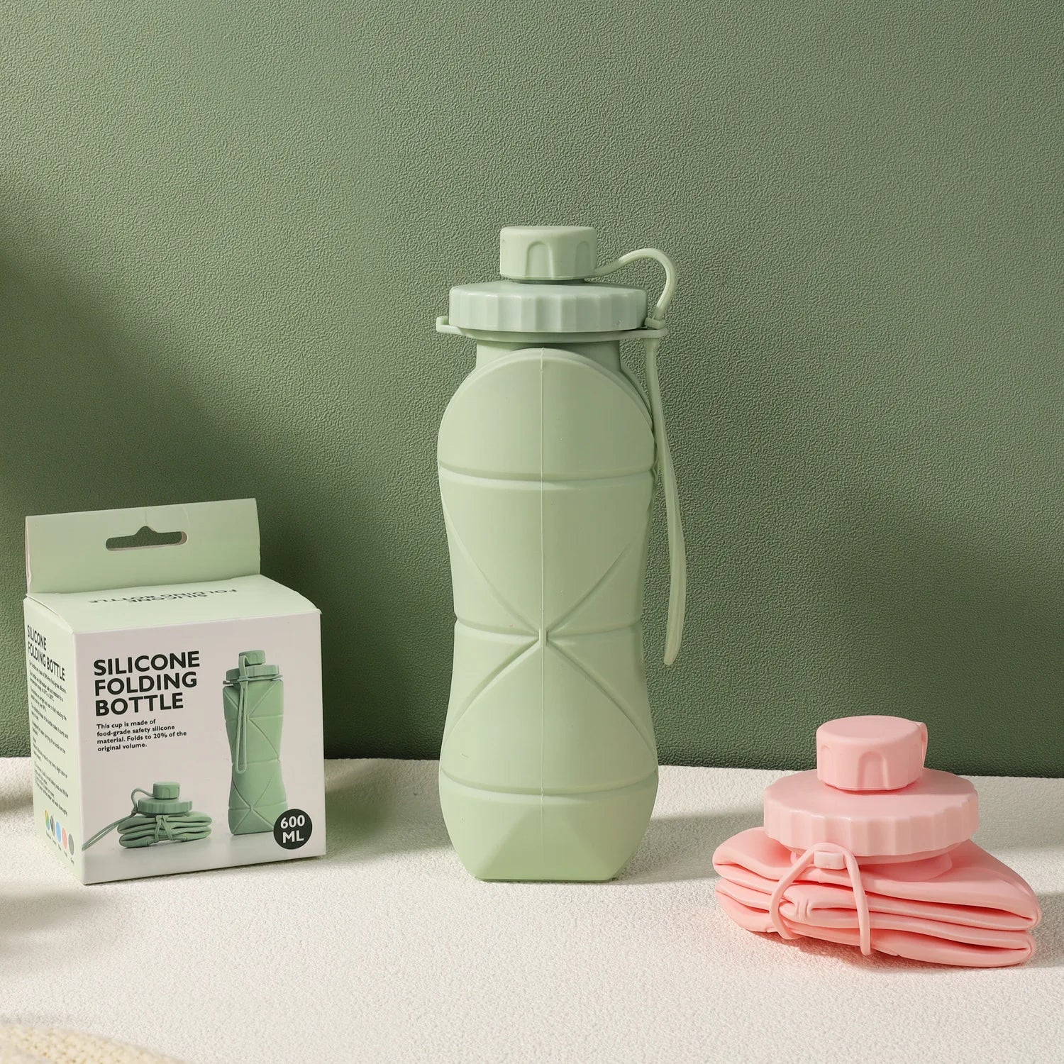 Bouteilles Flexi Hydra en silicone vert et rose, avec modèle vert déplié, modèle rose plié, et emballage 600 ml visible.