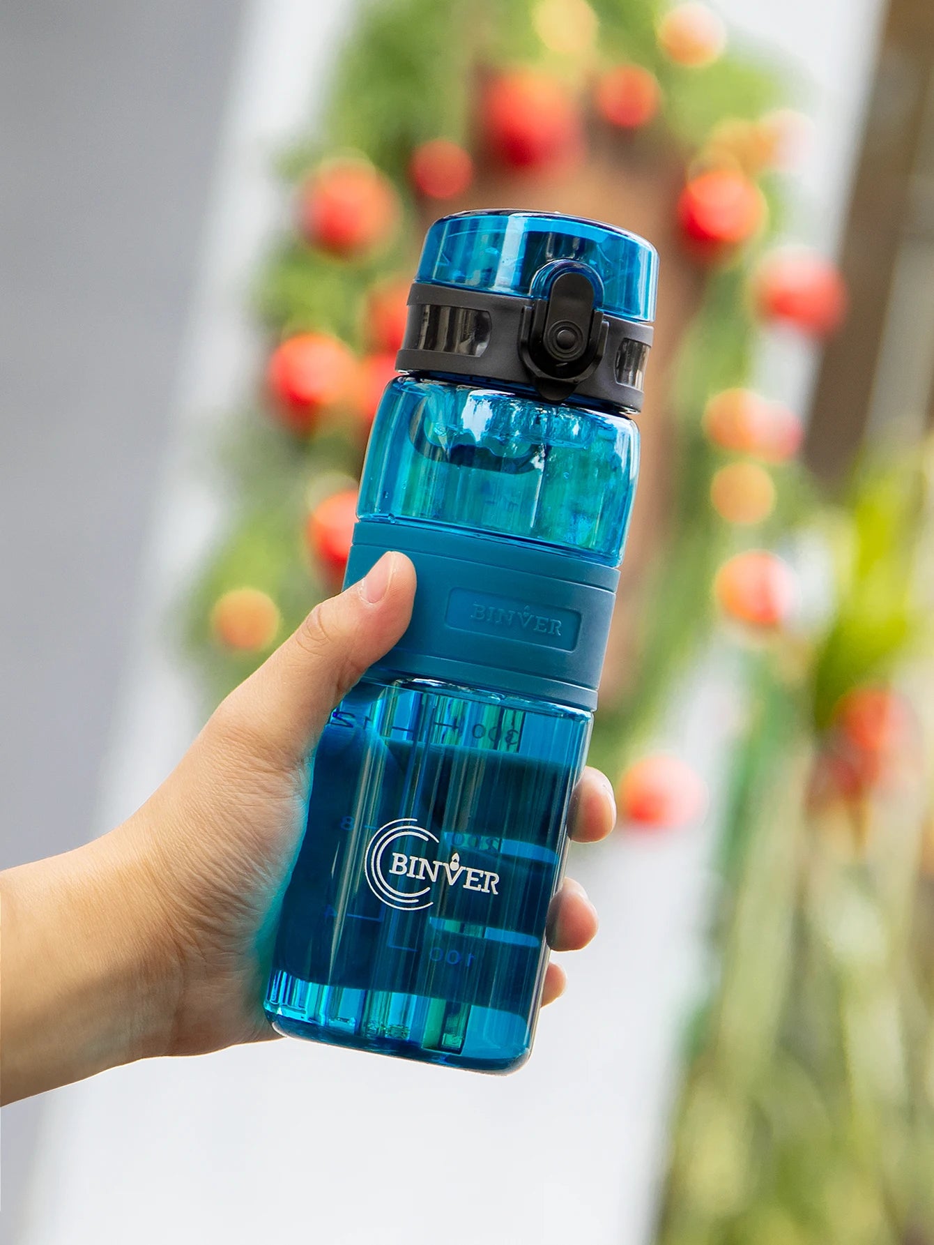Gourde Easy Clip bleu foncé tenue en main avec clip de sécurité intégré.