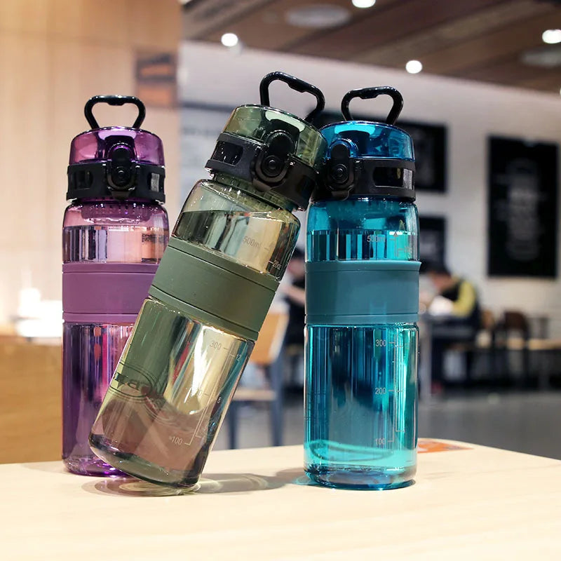 Trio de gourdes Easy Clip violette, olive et bleue avec bouchon sécurisé et format compact sur table.