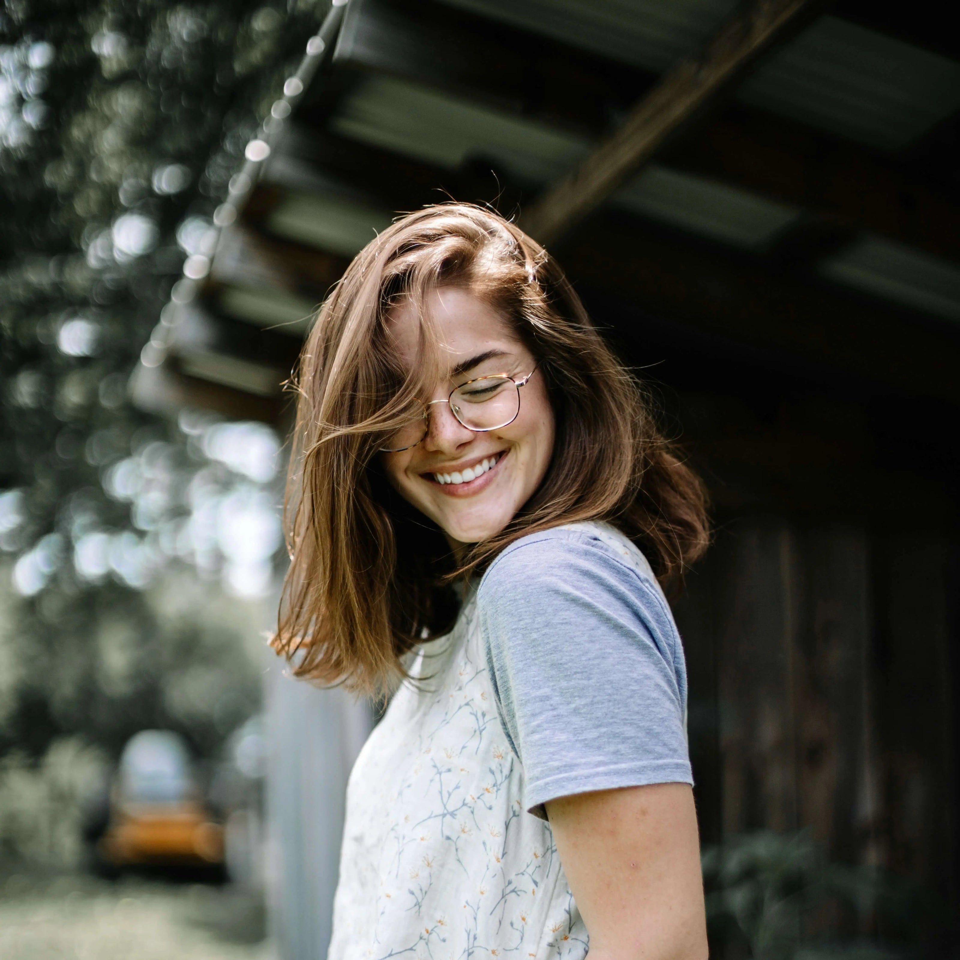 Femme souriante aux cheveux châtains en plein air avec t-shirt éthique.